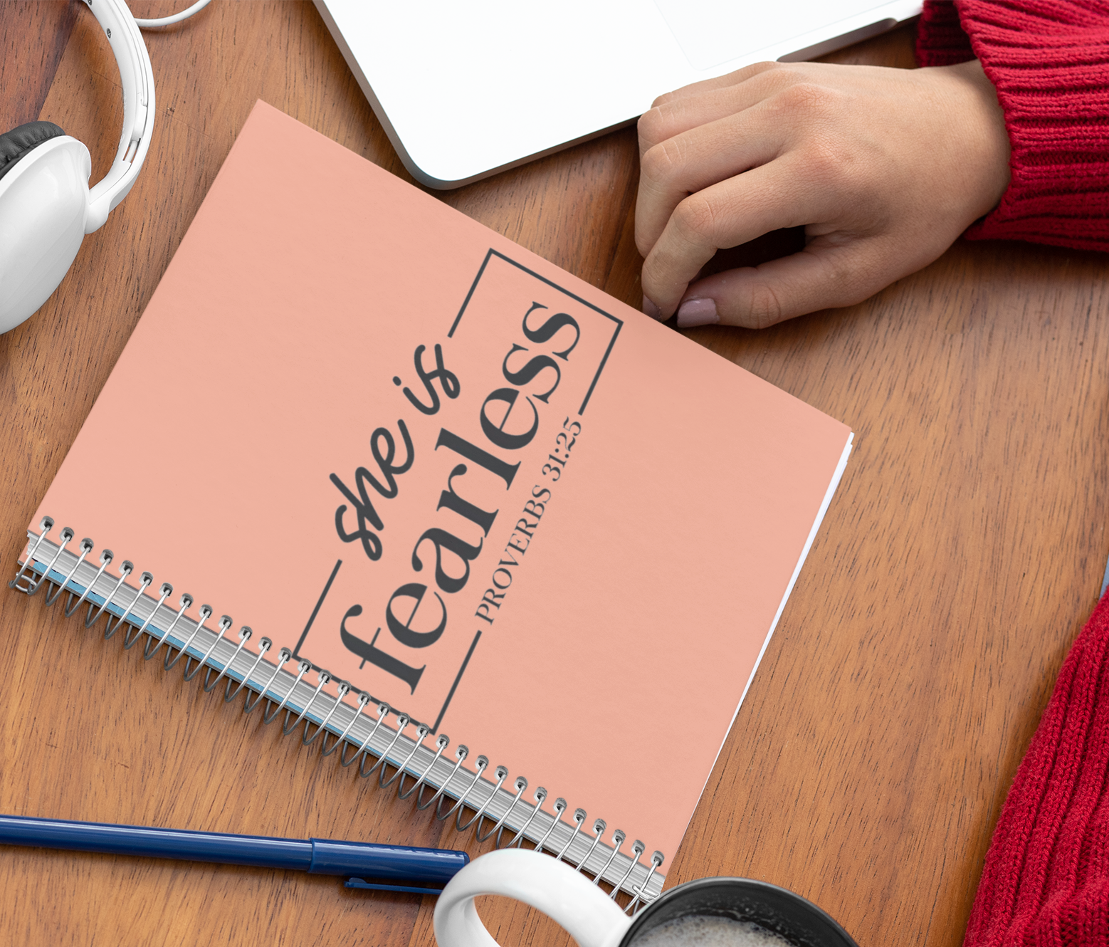 Spiral notebook with the words "She is Fearless" and the bible verse Proverbs 31:25